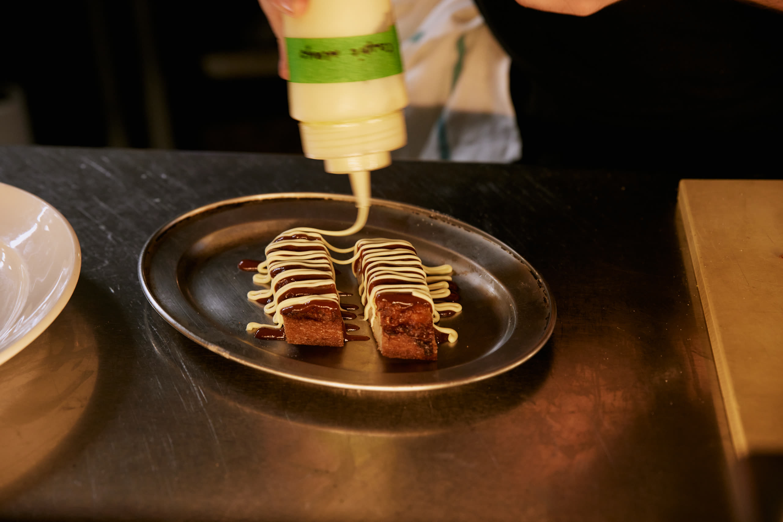 Prawn toast being finished at the pass